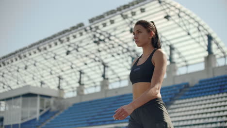 Slow-motion-portrait-of-beautiful-woman-running-on-the-stadium-bleachers-with-concentrated-deep-breathing-and-motivating-myself-and-consciousness-for-the-race.-Discard-unnecessary-emotions-and-tune-in-to-win-preparing-for-the-race